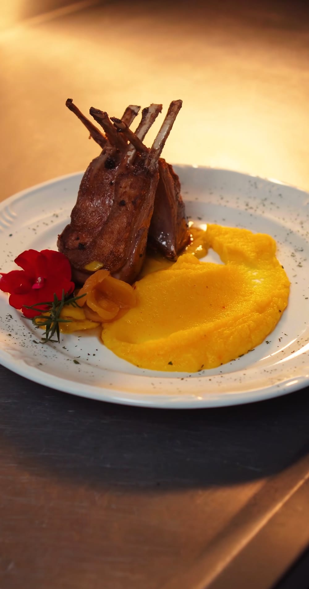 Carré de cordeiro com crosta de alecrim, molho de damasco e aligot de baroa